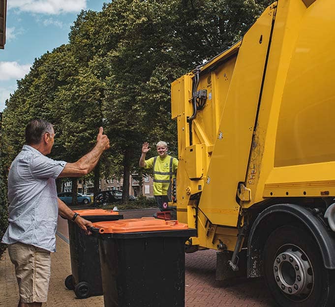 urger steekt vriendelijk hand op voor het legen van de container door Waardlanden